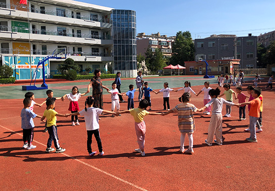 济南市汇泉小学阎洁老师带着孩子们在操场做游戏(刘祺 摄)